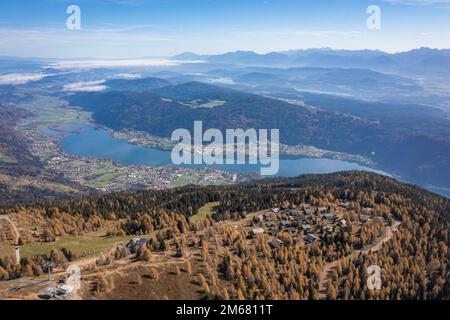 Touristisches Dorf am Gerlitzen-Berg in Kärnten. Malerisches Panorama des berühmten Ortes im Herbst mit Blick auf den ossiacher See. Stockfoto