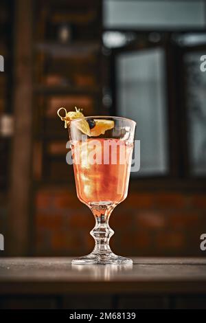 Kreativer Cocktail mit Orangensaft im Hintergrund. Stockfoto