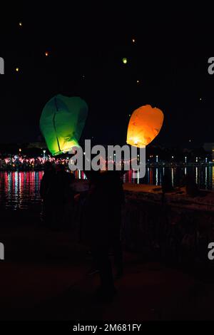 Die Menschen lassen viele Himmelslaternen frei, um die Lichter zu feiern, Spaß zu haben und sich in Volos, Griechenland, Wünsche zu machen Stockfoto