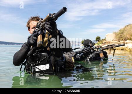 Mitglieder der USA Marinespezifische Sonderkriegseinheit Europa (NSWTU-E) und ein Mitglied der kroatischen Zapovjedništvo Specialjalnih Snaga (ZSS) führen am 15. April 2022 in Split (Kroatien) eine Übung über den Strand durch. Für das kroatische ZSS ist eine gemeinsame Austauschschulung oder JCET mit Partnerländern nicht ungewöhnlich. Das ZSS wurde 2000 als Sondereinsatzbataillon gegründet, und seitdem haben sich seine Betreiber an mehreren Operationen beteiligt, darunter Stationen in Afghanistan als Teil der Internationalen Sicherheitsbeistandstruppe (ISAF) der NATO. Stockfoto