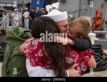 NORFOLK (16. April 2022) - Ein Matrose, der dem Arleigh-Burke-Klasse-Guided-Missile Destroyer USS Mitscher (DDG 57) zugeteilt wurde, umarmt seine Familie nach der Rückkehr des Schiffes zum Homeport, Marinestützpunkt Norfolk, April 16. Mitscher entsandte sich in das europäische Operationstheater und nahm an einer Reihe von maritimen Aktivitäten zur Unterstützung der Marinestreitkräfte Europa und der NATO-Alliierten Teil. Stockfoto