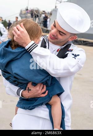 NORFOLK (16. April 2022) - Ein Matrose, der dem Arleigh-Burke-Klasse-Guided-Missile Destroyer USS Mitscher (DDG 57) zugeteilt wurde, umarmt seine Tochter nach der Rückkehr des Schiffes zum Homeport, Marinestützpunkt Norfolk, April 16. Mitscher entsandte sich in das europäische Operationstheater und nahm an einer Reihe von maritimen Aktivitäten zur Unterstützung der Marinestreitkräfte Europa und der NATO-Alliierten Teil. Stockfoto