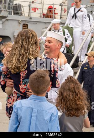 NORFOLK (16. April 2022) - Ein Matrose, der dem Arleigh-Burke-Klasse-Guided-Missile Destroyer USS Mitscher (DDG 57) zugeteilt wurde, umarmt seine Familie nach der Rückkehr des Schiffes zum Homeport, Marinestützpunkt Norfolk, April 16. Mitscher entsandte sich in das europäische Operationstheater und nahm an einer Reihe von maritimen Aktivitäten zur Unterstützung der Marinestreitkräfte Europa und der NATO-Alliierten Teil. Stockfoto