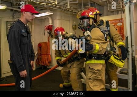 Derek Ruch aus St. Louis, der der Ingenieurabteilung der USS Gerald R. Ford (CVN 78) zugeordnet ist, leitet die Seeleute während eines allgemeinen Trainings in der Achterhalle am 16. April 2022 in der Brandbekämpfung ein. Ford ist im Atlantik unterwegs und führt vor dem operativen Einsatz Carrier-Qualifikationen und die Integration von Streikgruppen durch. CVN 78, Sailors, US Navy, USS Gerald R. Ford (CVN 78), Stockfoto