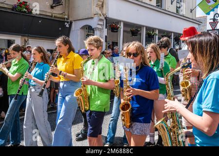 Schüler der Humphry Davy School spielen Windinstrumente während einer Parade am Mazey Day beim Golowan Festival in Penzance in Cornwall in Stockfoto