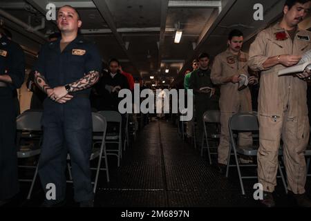 PHILIPPINE SEA (17. April 2022) LT. Luke Dundon, Zentrum, aus Chantilly, Virginia, beginnt den römisch-katholischen Osterdienst an Bord des Flugzeugträgers USS Abraham Lincoln (CVN 72) der Nimitz-Klasse. Die Abraham Lincoln Strike Group befindet sich in einem geplanten Einsatz im US-7.-Flottenbereich, um die Interoperabilität durch Allianzen und Partnerschaften zu verbessern und gleichzeitig als einsatzbereite Truppe zur Unterstützung einer freien und offenen Region Indo-Pacific zu fungieren. Stockfoto