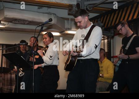 SEELEUTE AUS DER PHILIPPINEN SEE (17. April 2022) singen während der zeitgenössischen Osterfeier im Chor an Bord des Flugzeugträgers USS Abraham Lincoln (CVN 72) der Nimitz-Klasse. Die Abraham Lincoln Strike Group befindet sich in einem geplanten Einsatz im US-7.-Flottenbereich, um die Interoperabilität durch Allianzen und Partnerschaften zu verbessern und gleichzeitig als einsatzbereite Truppe zur Unterstützung einer freien und offenen Region Indo-Pacific zu fungieren. Stockfoto