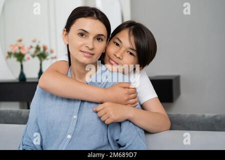 Porträt eines asiatischen Jungen, der Mutter zu Hause umarmt, Bild der Aktie Stockfoto