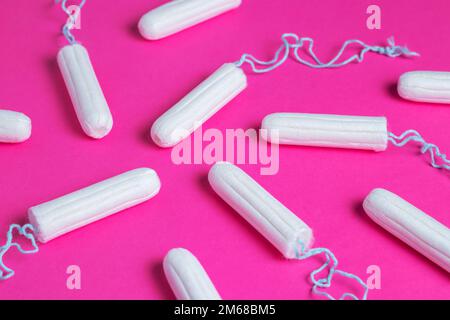 Medizinische weibliche Tampons auf rosa Hintergrund. Hygienischer weißer Tampon für Frauen. Wattestäbchen. Menstruation, Schutzmittel. Tampons auf einem roten Backgrou Stockfoto