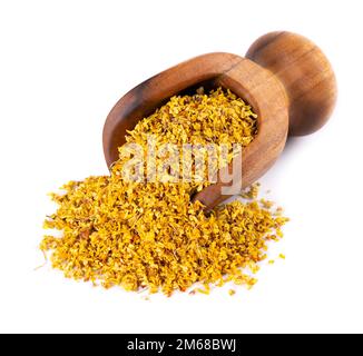 Osmanthus-Tee im Holzlöffel, isoliert auf weißem Hintergrund. Trockene Blüten von Osmanthus-Duftstoffen Stockfoto