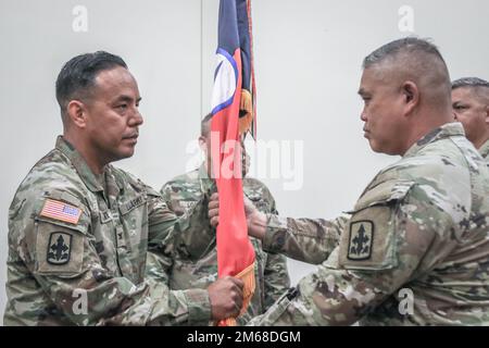 Oberst Jonathan A. Ishikawa, ehemaliger Befehlshaber des 29. Infanteriebrigaden-Kampfteams, erhält den Guidon von Kommandodienstleiter Shon K. Antolin während einer Zeremonie zur Änderung des Kommandos, Kalaeloa, Hawaii, am 18. April 2022. Das Überleben der Farben ist eine militärische Tradition von einem ausscheidenden Kommandeur zu einem ankommenden Kommandeur, um die Führung einer Einheit weiterzugeben. Stockfoto