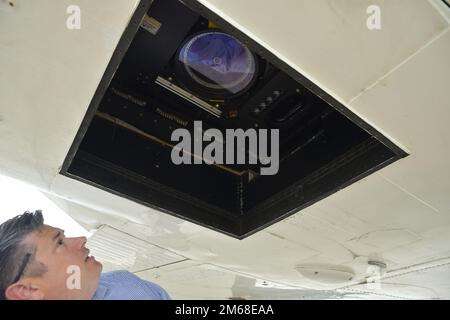 Chris Macon, technischer Leiter des National Coastal Mapping Program im Mobile District, inspiziert die Lidlinse vor einem Kalibrierungsflug am Stennis International Airport, Mississippi, 18. April 2022. Das Flugzeug, ein Beechcraft Super Air King 300, ist mit zwei Lidar-Sensoren und zwei hochauflösenden Kameras ausgestattet, die helfen, die notwendigen Daten und Bilder für das Kartierungsprogramm zu sammeln. Das Team des Joint Airborne Lidar Bathymetry Technical Center of Expertise sammelt Informationen über die Wasserstraßen und die Küste, um sicherzustellen, dass die USA Erfolg und Abschluss des Projekts des Armeekorps der Ingenieure. Stockfoto