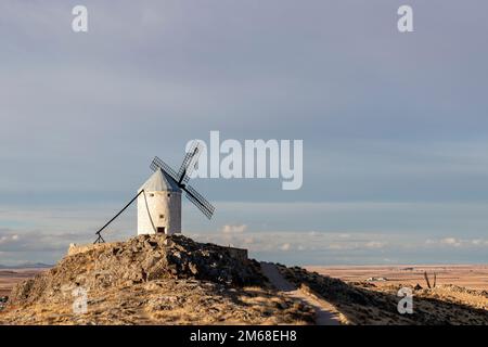 Gruppe alter Windmühlen in der Stadt Consuegra (Spanien), auf der Route der Mühlen Don Quijote und Cervantes, bei Sonnenuntergang Stockfoto