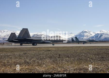 Zwei F-15C Eagles vom 144. Kampfflug und zwei F-22 Raptor vom 3. Kampfflug bereiten sich auf den Start von der Joint Base Elmendorf-Richardson, Alaska, am 18. April 2022 vor, während einer Aerospae Control Alert Trainingskampagne. Es ist fast ein Jahrzehnt her, seit F-15 Eagles in der Region wachsam waren und den Luftraum der Vereinigten Staaten und Kanadas schützen. Die allgemeine Alarmmission und die entsprechenden Ausbildungsmissionen bei JBER konzentrierten sich auf die Integration von Kämpfern zwischen F-15 Eagles der vierten Generation und F-22 Raptoren der fünften Generation und deren Fähigkeit, nahtlos miteinander zu arbeiten. Stockfoto