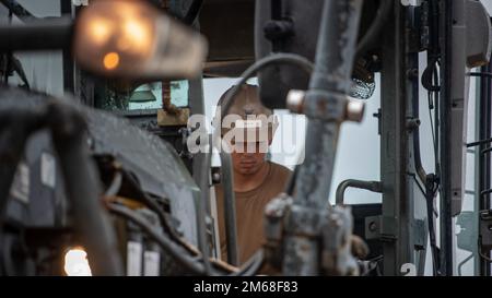 USA Navy Petty Officer 3. Klasse Rama Rudolph, eine Seebee, die dem Naval Mobile Construction Battalion 133 zugeteilt ist, betreibt einen Motorgrader auf dem Nordwest Field, Guam, 18. April 2022. Mitglieder des NMCB 133 wurden von Mitgliedern des 554. Rapid Engineering Deployable Heavy Operations Repair Squadron Engineer für den Betrieb von Schwermaschinen geschult. Stockfoto