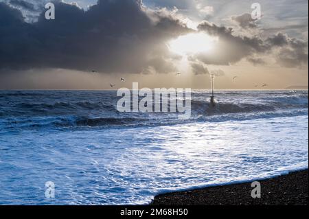 Dramatische Wolken über dem Meer und am Strand in Bexhill-on-Sea, Großbritannien Stockfoto