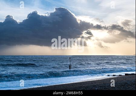 Dramatische Wolken über dem Meer und am Strand in Bexhill-on-Sea, Großbritannien Stockfoto