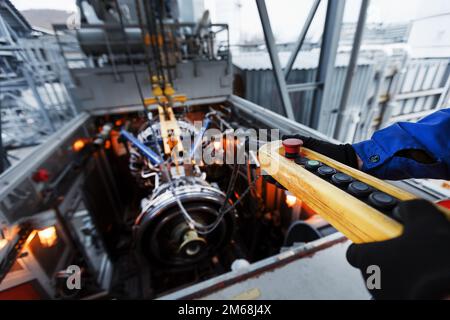 Der Motor eines Gasturbinenkompressors hängt während der Installation in einem Modul zur Stromerzeugung an einem Kran Stockfoto