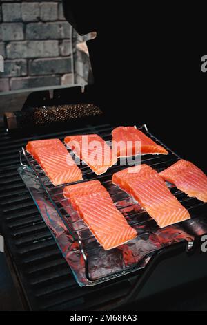 Nahaufnahme frischer Laiensteaks auf dem Grill mit Rauch Stockfoto
