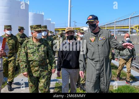 MISAWA, Japan (19. April 2022) – Hauptmann Paul A. Hockran, rechts, Befehlshaber der Naval Air Facility (NAF) Misawa, führt Generalleutnant Shinji Kameyama, Left, Befehlshaber der 9. Division der japanischen Selbstverteidigungskräfte (JGSDF) und andere JGSDF-Mitglieder durch. Der Zweck der Tour bestand darin, Kommunikationsbemühungen und die Verteilung von Kraftstoff zu besprechen. NAF Misawa bietet Unterstützung und Dienstleistungen für die Luftfahrt- und Bodenlogistik in allen permanenten und transienten USA Navy und USA Marinekorps in Nordjapan. Stockfoto