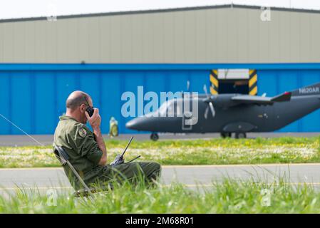 Ein belgischer Dispatcher (Sprungmeister), der dem Schulungszentrum CE para zugewiesen ist, übermittelt Fluginformationen, da Fallschirmjäger am 19. April 2022 auf dem Luftwaffenstützpunkt Chièvres, Belgien, Schulungen zum Thema Nachhaltigkeit durchführen. Stockfoto