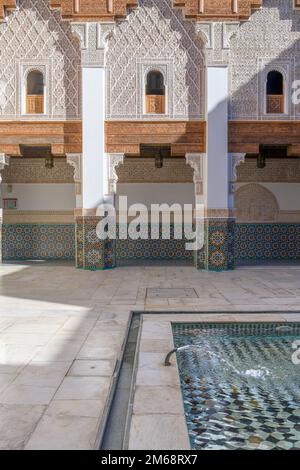 Ben Youssef Madrasa in Marrakesch war ein islamisches College. Die Wände und der Boden sind mit farbenfrohen Zellij-Fliesen in islamischen Mustern bedeckt. Stockfoto