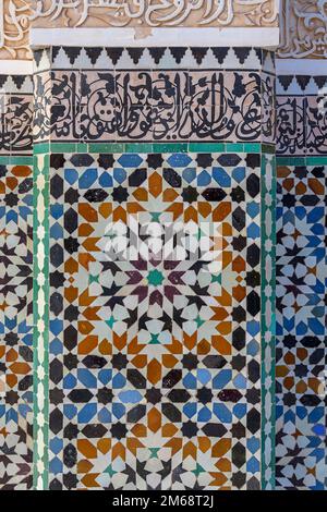 Ben Youssef Madrasa in Marrakesch war ein islamisches College. Die Wände und der Boden sind mit farbenfrohen Zellij-Fliesen in islamischen Mustern bedeckt. Stockfoto