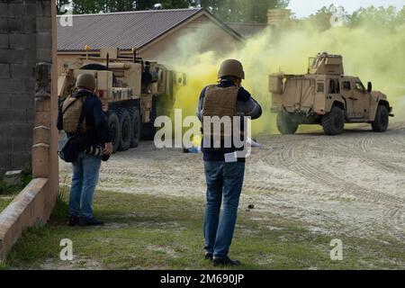 Thomas Nielsen, ein Redakteur von Barents Observer, macht Bilder von den USA Marines mit Combat Logistics Battalion 6, während sie eine Fahrzeugbergung durchführen, während sie unter simuliertem feindlichem Feuer in Camp Lejeune, North Carolina, am 21. April 2022 stehen. II Marine Expeditionary Force (MEF) veranstaltete in Abstimmung mit 2. MLG einen Medientag für Mitglieder der norwegischen Medien, um die Fähigkeiten und die Ausbildung des MEF zu beobachten und darüber zu berichten. Stockfoto