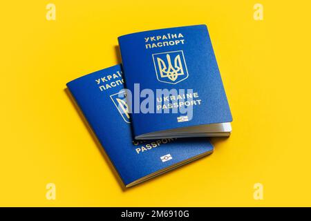 Ukrainischer Pass auf gelbem Hintergrund. Der Pass des ukrainischen Staatsbürgers im Makro. Reisepass Allgemeiner Plan und Nahaufnahme. Stockfoto