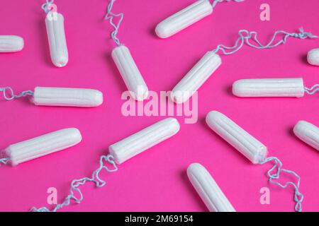 Medizinische weibliche Tampons auf rosa Hintergrund. Hygienischer weißer Tampon für Frauen. Wattestäbchen. Menstruation, Schutzmittel. Tampons auf einem roten Backgrou Stockfoto