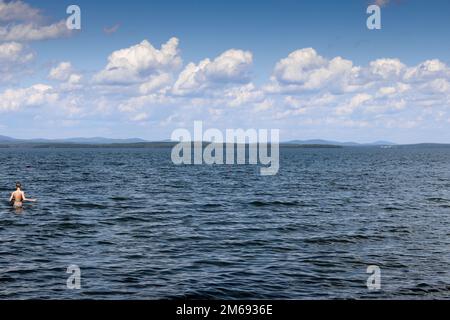 Die Wasseroberfläche des Lake Uvildy vor einem wolkigen Himmel an einem Sommertag. Das Foto wurde am Ufer des Lake Uvildy, Chelyabinsk Region, Russland aufgenommen. Stockfoto