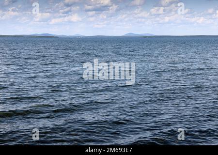 Die Wasseroberfläche des Lake Uvildy vor einem wolkigen Himmel an einem Sommertag. Das Foto wurde am Ufer des Lake Uvildy, Chelyabinsk Region, Russland aufgenommen. Stockfoto