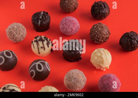 Fotoschokolade mit verschiedenen Dekorationen auf rotem Hintergrund Stockfoto