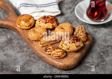 Salzige Kekse auf dunklem Hintergrund. Sesam- und Samenkekse auf einem Servierteller aus Holz. Schließen Stockfoto