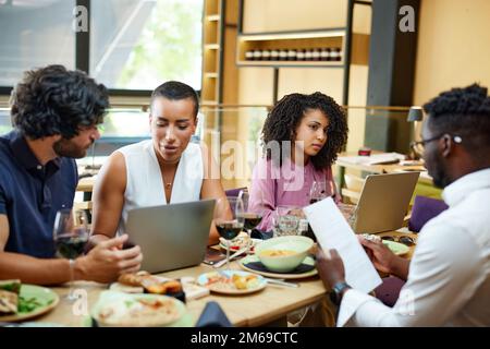 Firmenangestellte veranstalten während des Mittagessens zwanglose Geschäftstreffen in einem Restaurant. Stockfoto