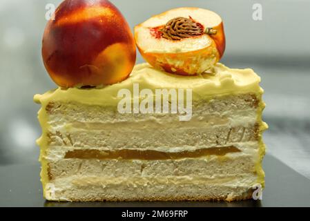 Ein bunter Kuchen steht auf einem schwarzen Tisch Stockfoto