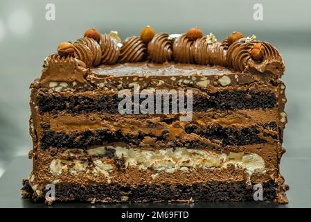 Ein bunter Kuchen steht auf einem schwarzen Tisch Stockfoto