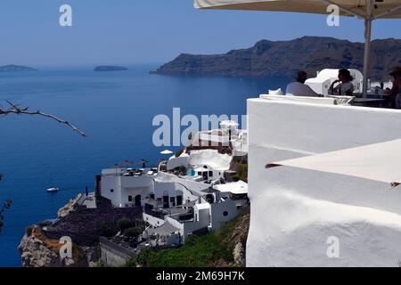 Oia, Santorin, Griechenland - 22. Juni 2022: Blick auf das Ägäische Meer von der Stadt Oia, die weißen Häuser sind auf den Klippen mit Blick auf die Caldera gebaut Stockfoto