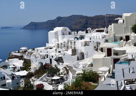 Oia, Santorin, Griechenland - 22. Juni 2022: Blick auf die Stadt Oia, die weißen Häuser sind auf den Klippen mit Blick auf die Caldera erbaut, einige Gebäude haben das Stockfoto