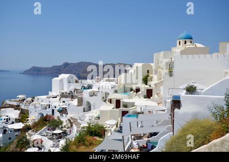 Oia, Santorin, Griechenland - 22. Juni 2022: Blick auf die Stadt Oia, die weißen Häuser sind auf den Klippen mit Blick auf die Caldera gebaut Stockfoto