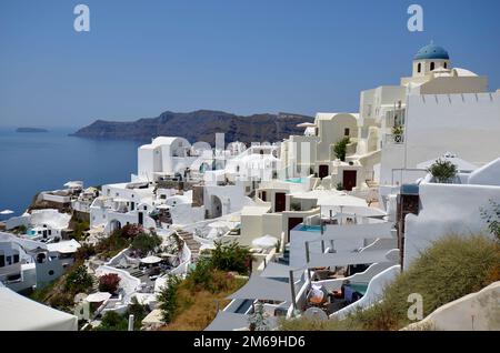 Oia, Santorin, Griechenland - 22. Juni 2022: Blick auf die Stadt Oia, die weißen Häuser sind auf den Klippen mit Blick auf die Caldera gebaut Stockfoto