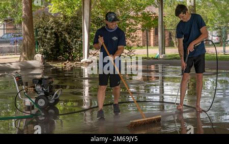 Seaman Mitchell Tovalski (links) und Seaman Devin Greene (rechts), beide meereswissenschaftliche Techniker des Küstenwachsektors New Orleans, waschen während der Navy Week New Orleans am 21. April 2022 ein Basketballfeld auf dem Evans Playground. Die Navy Week New Orleans ist eine wichtige Gelegenheit für Bürger, ihre Soldaten der Marine, des Marine Corps und der Küstenwache zu treffen. MARFORRES, MARINES, Navy, New Orleans, Reserven, Stockfoto
