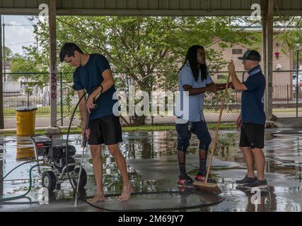 Cash Cobbins (Mitte) ein Mitarbeiter der New Orleans Recreation Development Commission beauftragt Seamen Mitchell Tovalski (rechts), während Seamen Devin Greene (links), beide meereswissenschaftliche Techniker des Küstenwachsektors New Orleans, während der Navy Week New Orleans, 21. April 2022, ein Basketballfeld auf dem Evans Playground mit Strom versorgt. Dieses Jahr ist die 4. Flottenwoche in New Orleans, seit die Flottenwochen 2012 begannen, um den 200. Jahrestag der Schlacht von New Orleans zu feiern. MARFORRES, MARINES, Navy, New Orleans, Reserven, Stockfoto