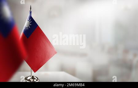 Kleine Flaggen Taiwans auf abstraktem, verschwommenem Hintergrund. Stockfoto