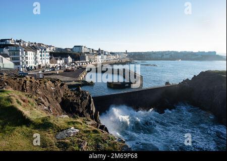 Portstewart, UK - 2. Januar 2023: Wellen schlagen gegen die Ufermauer am Hafen in Portstewart, Nordirland Stockfoto