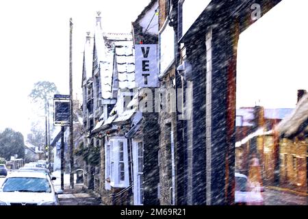 Sharnbrook, Bedfordshire, England, Großbritannien - Stone hat Hütten, Geschäfte und eine Kneipe in der Hauptstraße des Dorfes während eines schweren Schneefalls erbaut Stockfoto