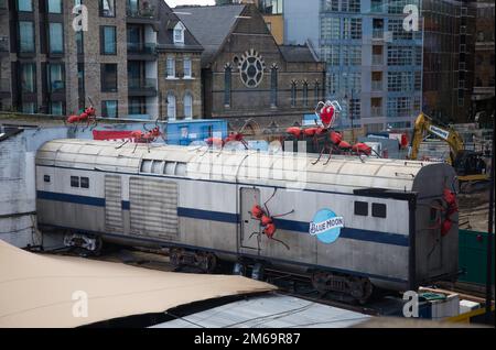 Rote Ameisenskulpturen, die in einem Restaurant in London Bridge, London, Großbritannien, über eine Zugkutsche krabbeln Stockfoto