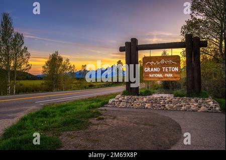 Begrüßungsschild am Eingang zum Grand Teton National Park in Wyoming bei Sonnenuntergang Stockfoto