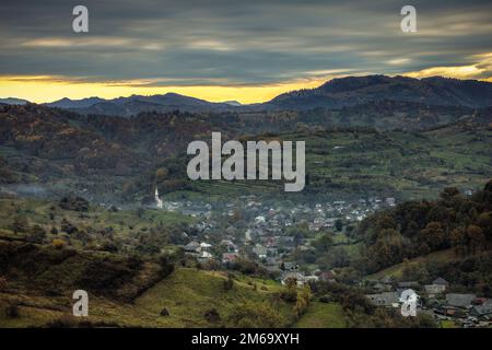 Dramatischer Sonnenaufgang über dem alten, historischen Dorf Bocicoel. Foto aufgenommen am 22. Oktober 2022 im Dorf Bocicoel, Kreis Maramures, Rumänien Stockfoto