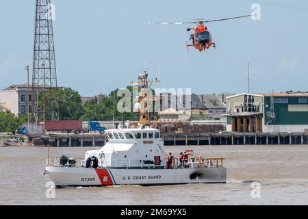 Coast Guard Air Station New Orleans MH-65 Dolphin Helikopter und Coast Guard Cutter Tiger Shark führt Training während der NOLA Navy Week in New Orleans, Louisiana, 21. April 2022 durch. AIRSTA NOLA, CGC Tigerhai, Hoist, NAVY WEEK, NOLA, Stockfoto
